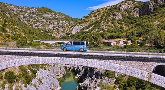 Blue VW Camper crossing a bridge