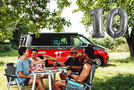 family in front of red camper