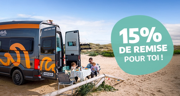 Family of four sitting in the doorway of a campervan