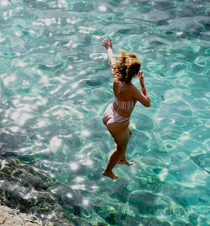Woman jumping into water.