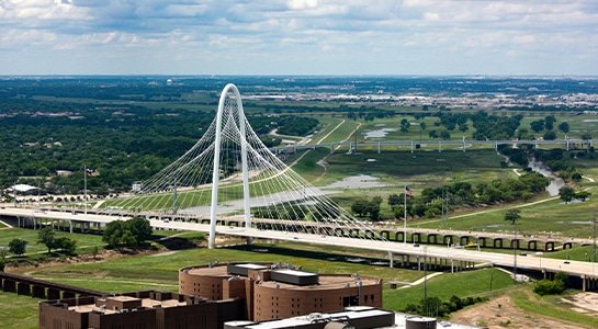 Margaret Hunt Hill Bridge in Dallas with green landscape around it.
