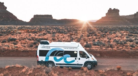 RV driving through the Arizona desert at sunset with scenic mountains in the background