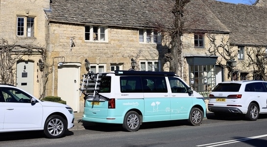 Turquoise campervan parked on the road in the Cotswolds