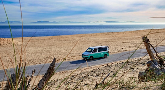 Camper van on the road, ocean in the background