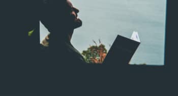 silhouette of man with book