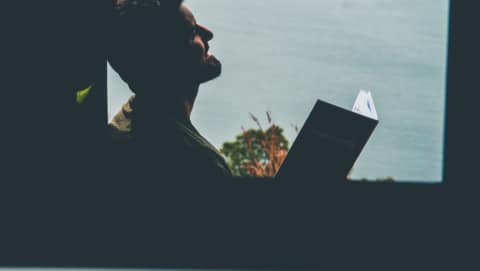 silhouette of man with book