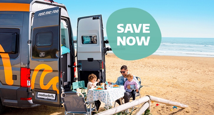 Family Having Picnic on Beach with Campervan EN