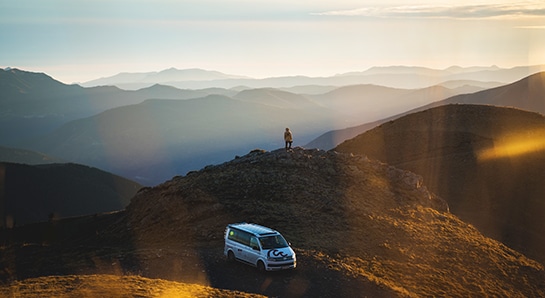 Volkswagen camper standing on the top of the mountains with views to the horizon