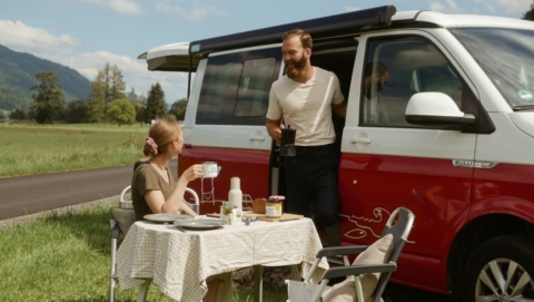 A Couple Eating Breakfast Outside Of Their Camper Van