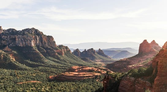 panoramic view of Sedona’s red rock cliffs and green valleys, a highlight of any Arizona road trip itinerary