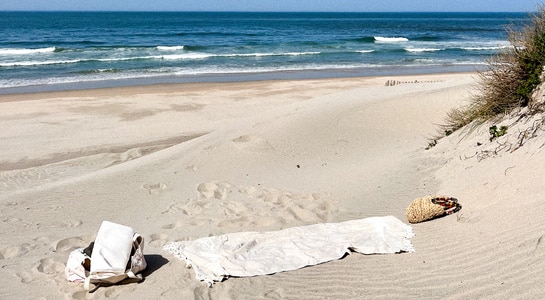 Beach towel placed in sand with view over the sea.