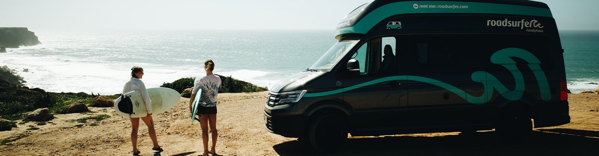 RV parked along the California coast near surfers overlooking the ocean, showcasing the best surfing in California