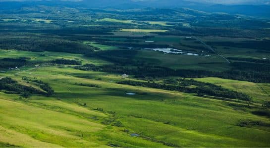 Rolling green hills and wide open landscape in Alberta along a Calgary to Vancouver road trip
