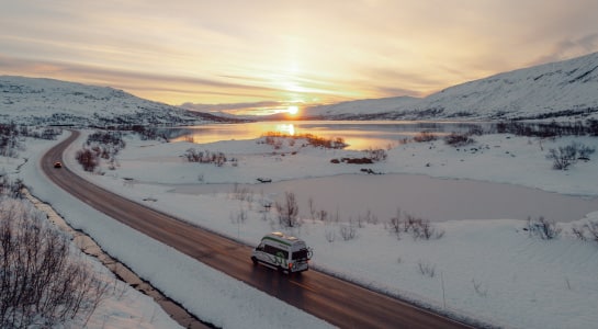 Campervan driving through snowy landscape
