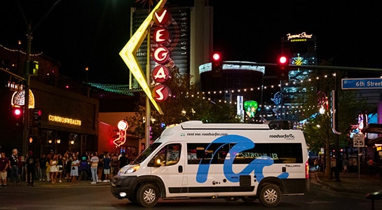 roadsurfer camper in Las Vegas city in front of blinking signs