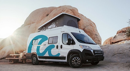 roadsurfer camper on a campground in front of a big rock in the usa