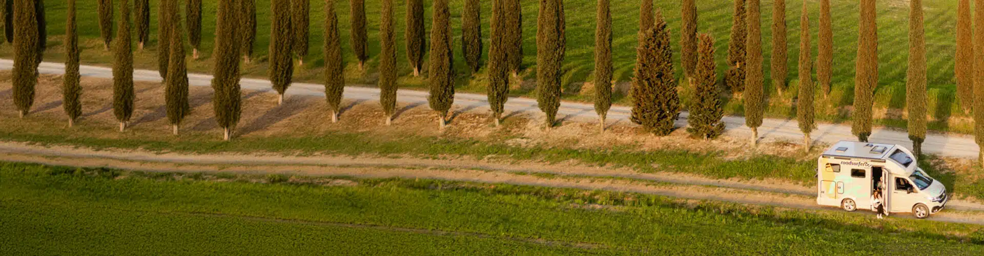 Couple driving a camper on the road in Tuscany