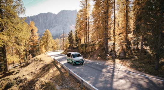camper van driving on a road in the mountains