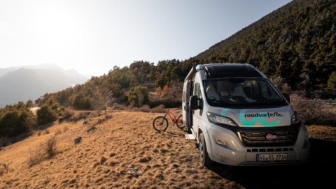 campervan and a bike on a road in the mountains