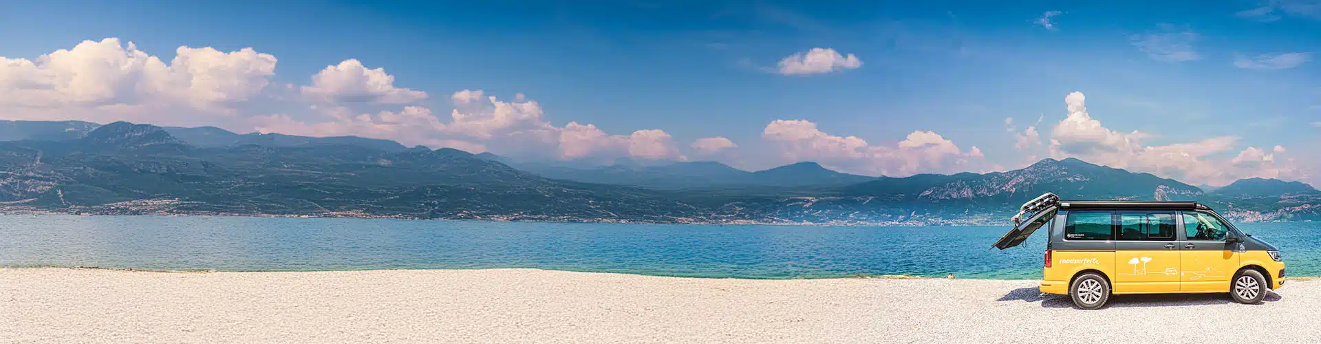 Campervan at the beach in fron of the mountains in Liguria