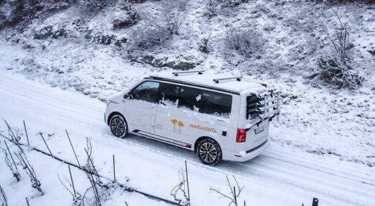 Campervan driving on a snowy road in winter