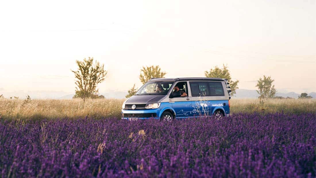 campervan with couple in a purple lavender field
