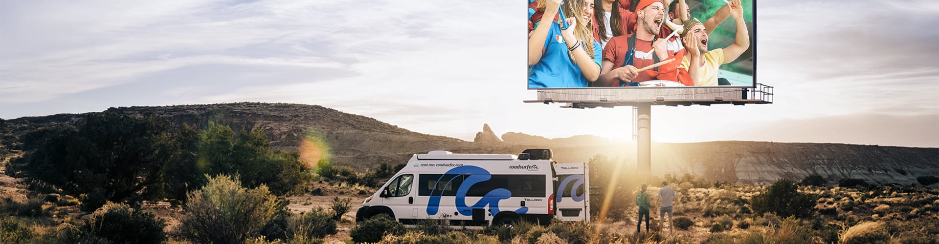 Campervan parked in nature at sunset with a billboard in the background schowing football fans