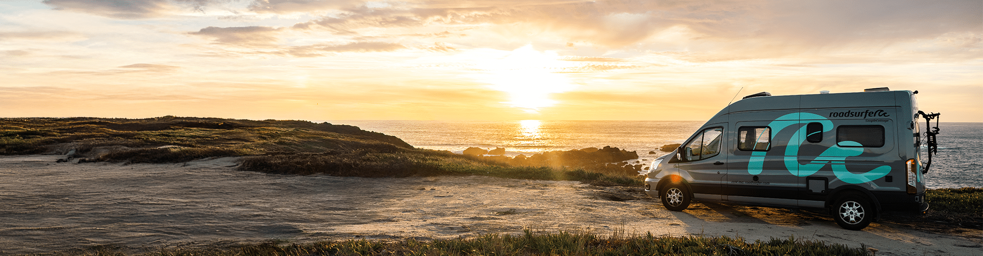 A roadsurfer campervan standing next to the portuguese coast with a beautiful sunset in the front