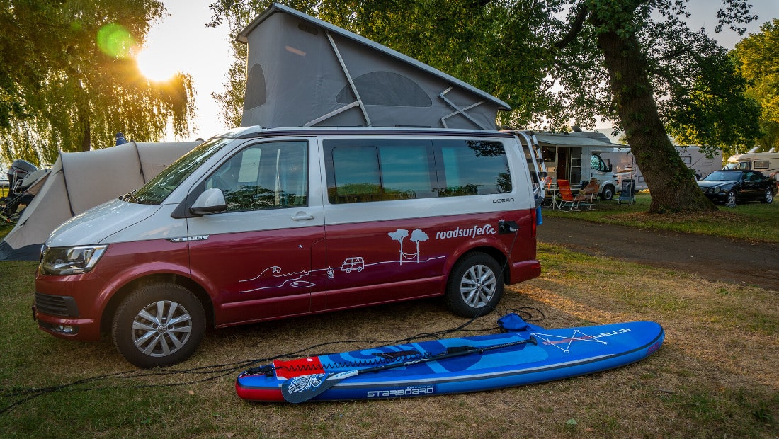 campervan with sup board on a campsite