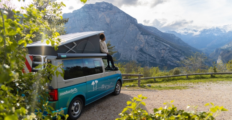 Campervan standing on a mountain street with mountain panorama