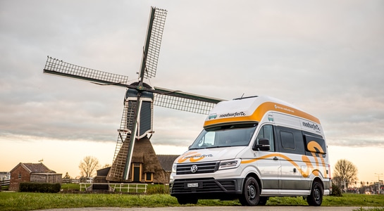 roadsurfer campervan standing in front of a windmill in Netherlands