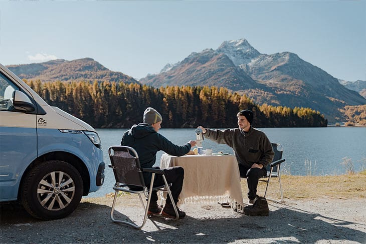 couple having a break with their campervan at a lake