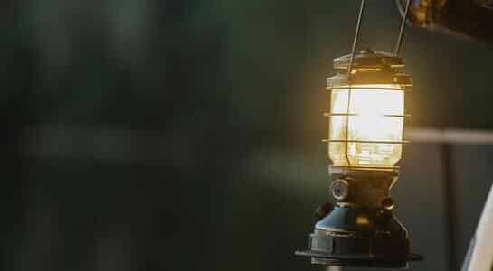Camping lantern shining its light in the darkness.