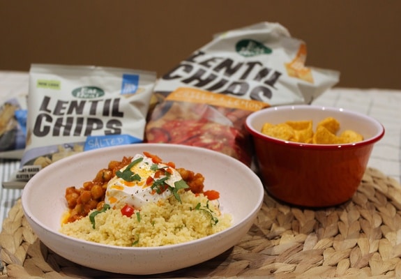 Delicious chickpea tomato, harissa stew and couscous with crispy chip topping view from the side