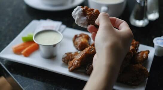 Chicken Wings served on a plate with carros and ranch dressing.