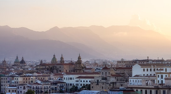 City view over Palermo with the sicilian mountains in the back illuminated by the daylight.