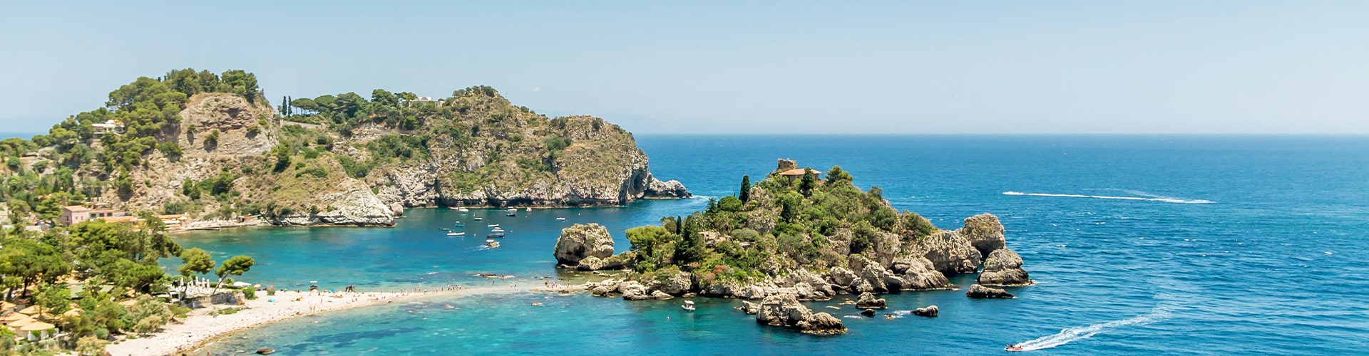 View over the blue sea surrounded by cliffs and a sandy beach in Sicily.