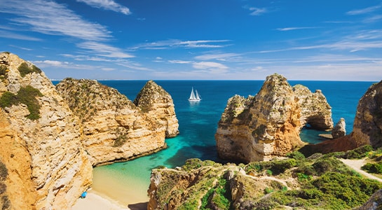 View over a beach in Portugal surrounded by high cliffs.