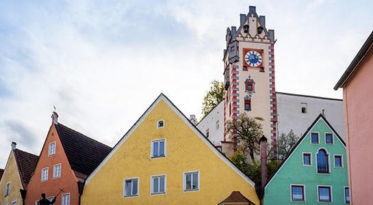 Colorful houses in Füssen, Germany showing the church tower in the background.
