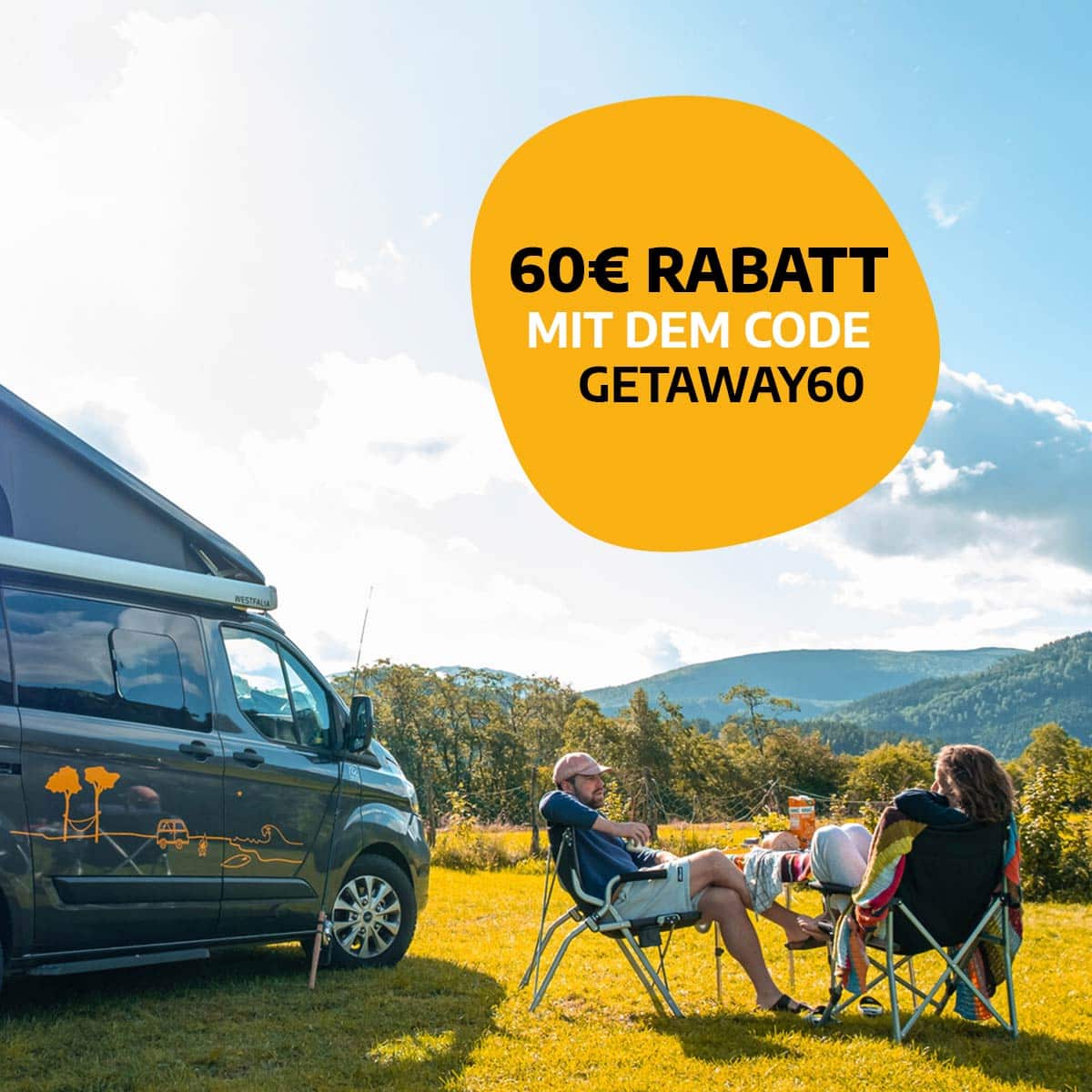 couple at a picknick table on a lawn next to a campervan