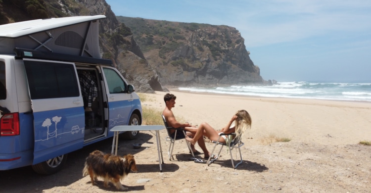 couple sitting in front of their van