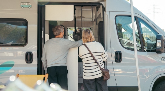 Couple checking the inside of a sprinter-type campervan