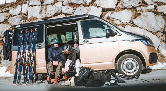 couple getting dressed for skiing in a campervan