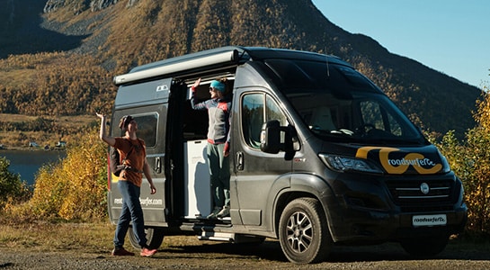 couple high five in front of a motorhome after a hike