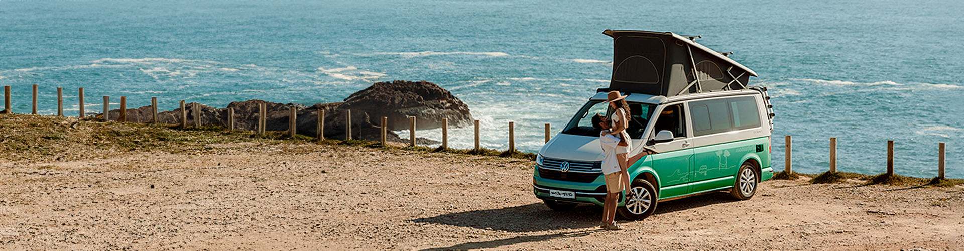 Couple in front of a campervan with ocean in the background