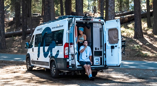 couple in the back of a camper van in the forest