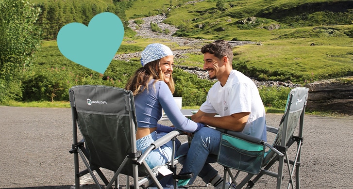Couple sitting at camping table love campaign