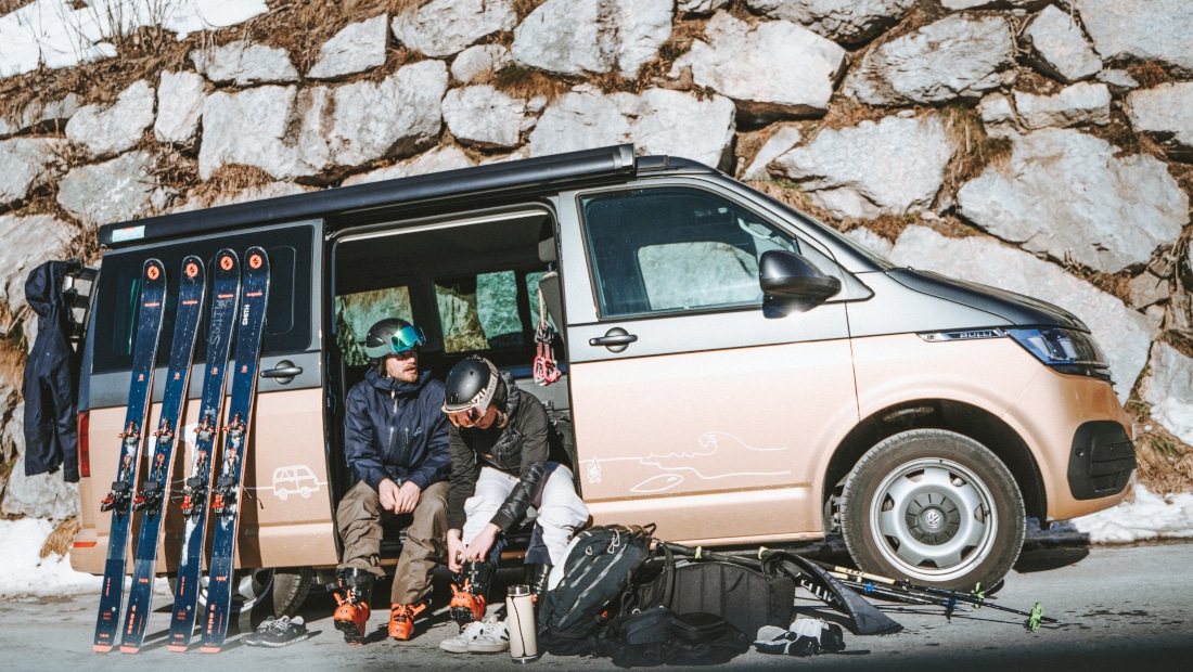 couple in a van, putting on their shoes for skiing