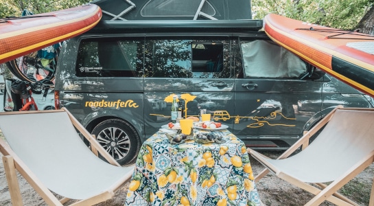 decorated picknick table and chairs in front of a campervan