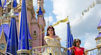 Disney princesses waving from a parade float in front of the Cinderella Castle at Disney World